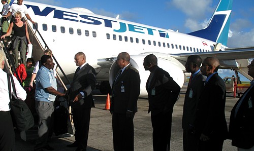 A leur arrivée à Bridgetown, les passagers de ce vol inaugural ont été accueillis par de nombreux journalistes et dignitaires, dont l'Honorable Richard L. Sealy, Ministre du tourisme. (le premier dans la ligne)