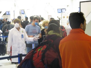 Aéroport de Mexico ce matin : un agent de la santé guide les voyageurs vers une '' scanneur'' de fièvre Aéroport de Mexico ce matin : un agent de la santé guide les voyageurs vers une '' scanneur'' de fièvre
