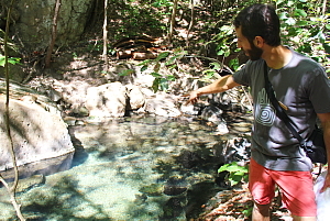 Gabriel Saragovia, responsable des marchés du Rio Perdido, nous montre les sources thermales qui émergent sous les rochers et réchauffent les bassins de la rivière.