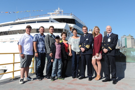 Le 100 000e passager du Maasdam à débarquer à Montréal, Mme Marianne Visser, entourée de sa famille, du capitaine du navire, M. Ane Jan Smit et des représentants du Port de Montréal. (Groupe CNW/Tourisme Montréal)