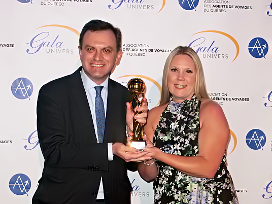 Christy King de Palladium Hotel Group remet le trophée au  consul de Grèce à Montréal, Nikolaos Karalekas.