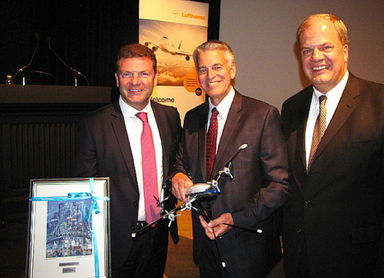 Jens Bischof et Hans DeHaan de Lufthansa entourent Pierre-Paul Pharand de Aéroports de Montréal suite à un échange de cadeaux remarquables. Jens Bischof et Hans DeHaan de Lufthansa entourent Pierre-Paul Pharand de Aéroports de Montréal suite à un échange de cadeaux remarquables.