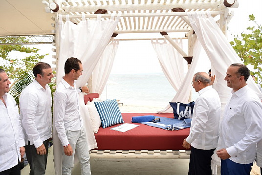 Xavier Mufraggi (à gauche), Président Directeur Général Club Med Amérique du Nord et H. E. Danilo Medina Sánchez (à droite), Président de la République dominicaine, ouvrant officiellement les rideaux sur le premier élément iconique de Club Med Michès – la première palapa – durant l’évènement de première pelletée officielle’