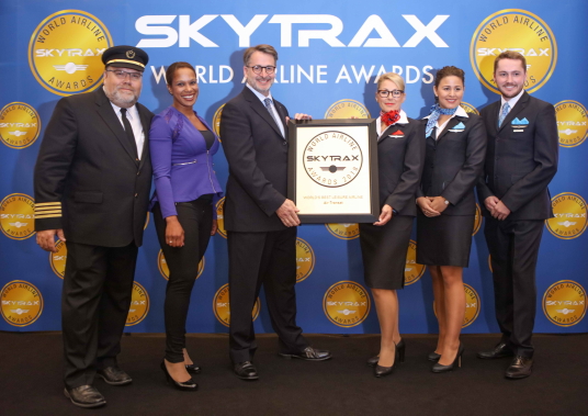 Jean-François Lemay, président-directeur général d’Air Transat (au centre), accompagné de membres du personnel naviguant d’Air Transat et d’une représentante de Skytrax.