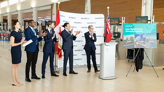 De G à D : Christina Iversen, WestJet, directrice des affaires extérieures, Jamie Moses, ministre du développement économique, de l’investissement, du commerce et des ressources naturelles du Manitoba, Nick Hays, président et pdg de l'Administration aéroportuaire de Winnipeg, l’Honorable Wab Kinew, Premier ministre du Manitoba et Mike Scott, vice-président directeur et chef des finances du groupe WestJet.