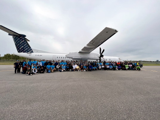 Les 17 équipes de la compétition Haul for Hope posent devant l'avion de 67 000 livres de Porter Airlines que chaque équipe a tiré sur 100 mètres. (Groupe CNW/Aéroport Billy Bishop de Toronto)