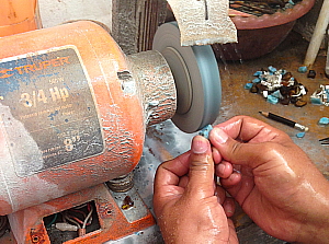 Un artisan en train de polir la pierre Larimar dans une échoppe de Puerto PLata